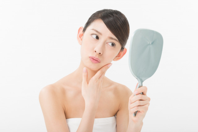 鏡を見る女性の写真